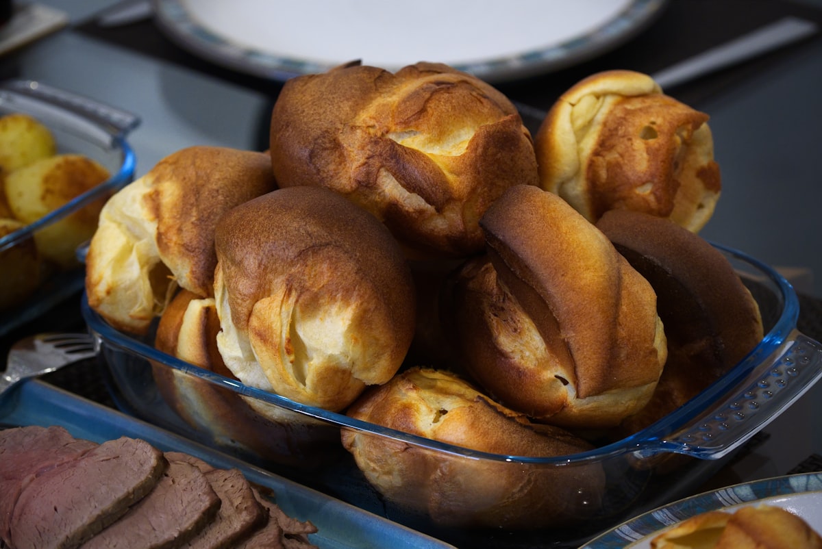 Golden brown yorkshire puddings in a glass dish